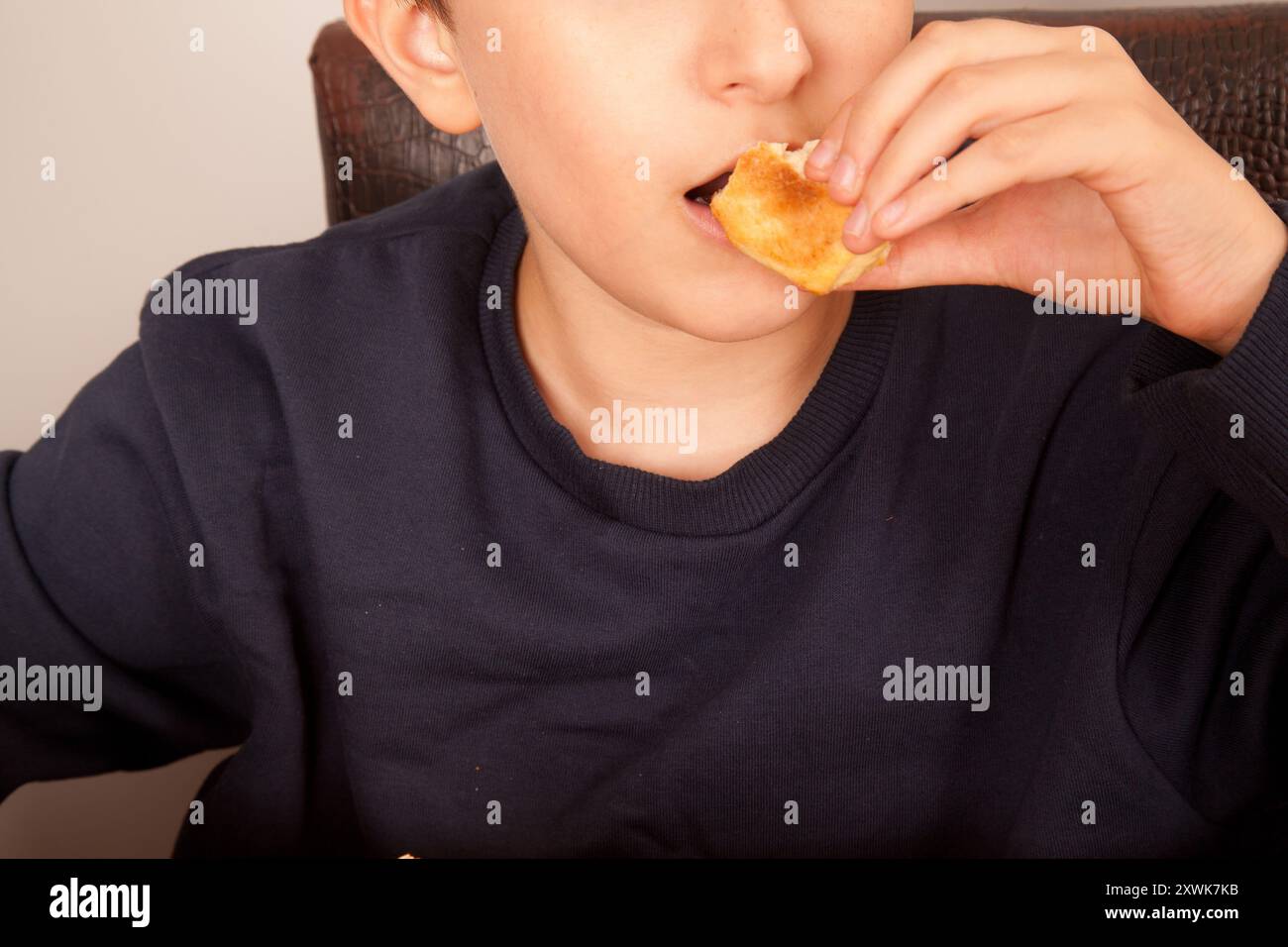 Un uomo caucasico mangia hamburger di sesamo fresco e mezza mangiato, cultura fast food americana Foto Stock