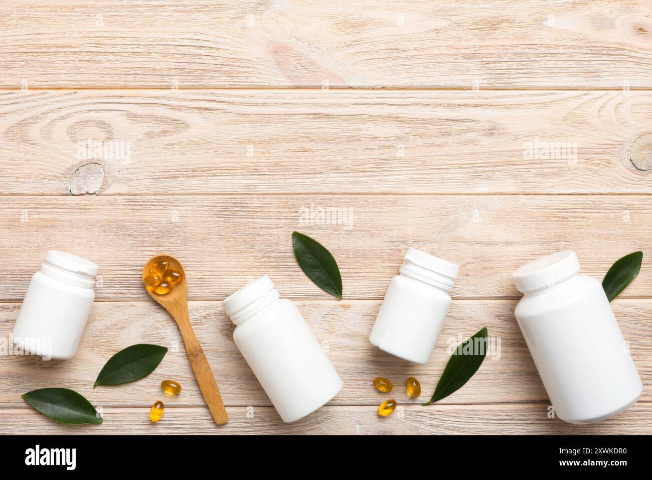 Le capsule di Omega-3 si trovano in un flacone bianco su un tavolo con il fondo verde delle foglie. Compresse di olio di pesce. Additivi biologicamente attivi omega 6, omega 9, vitam Foto Stock