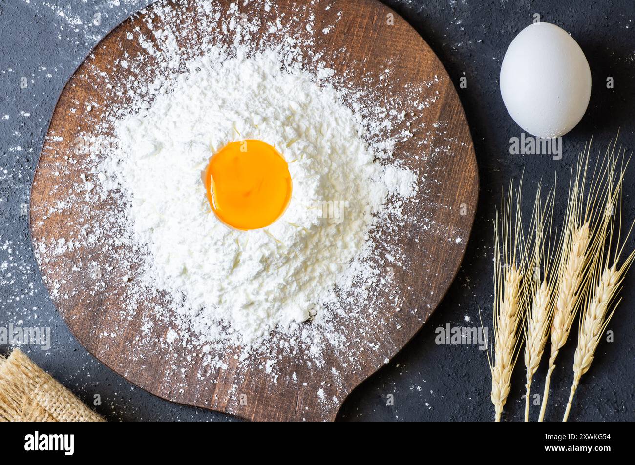 Preparare l'impasto, cuocere gli ingredienti farina le uova su un tavolo rustico Foto Stock