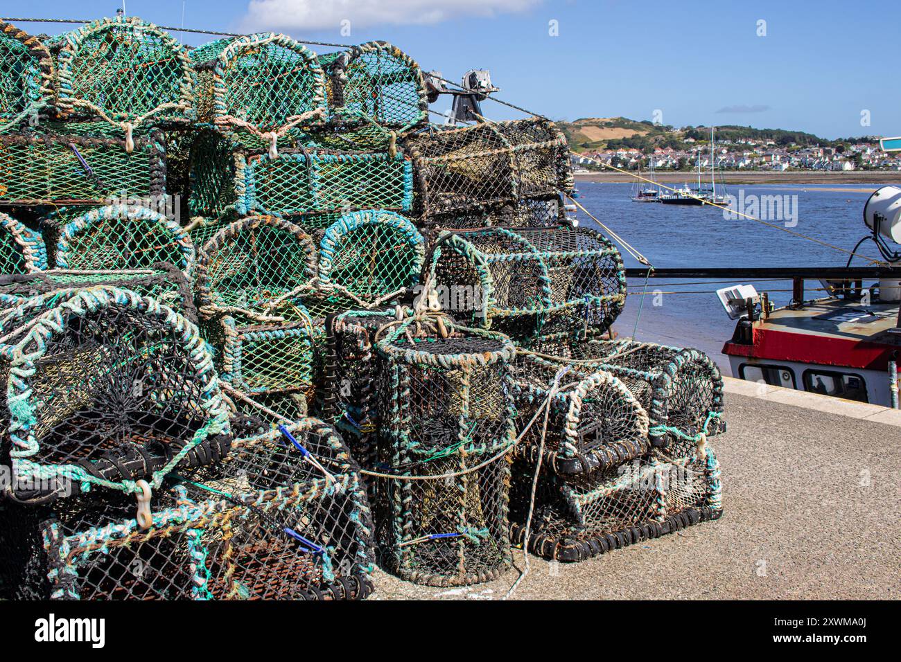 Pozze di aragosta in attesa sulla banchina della città fortificata di Conwy costruita da re Edoardo i sul rettilineo di Menai ad Anglesey, Galles Foto Stock