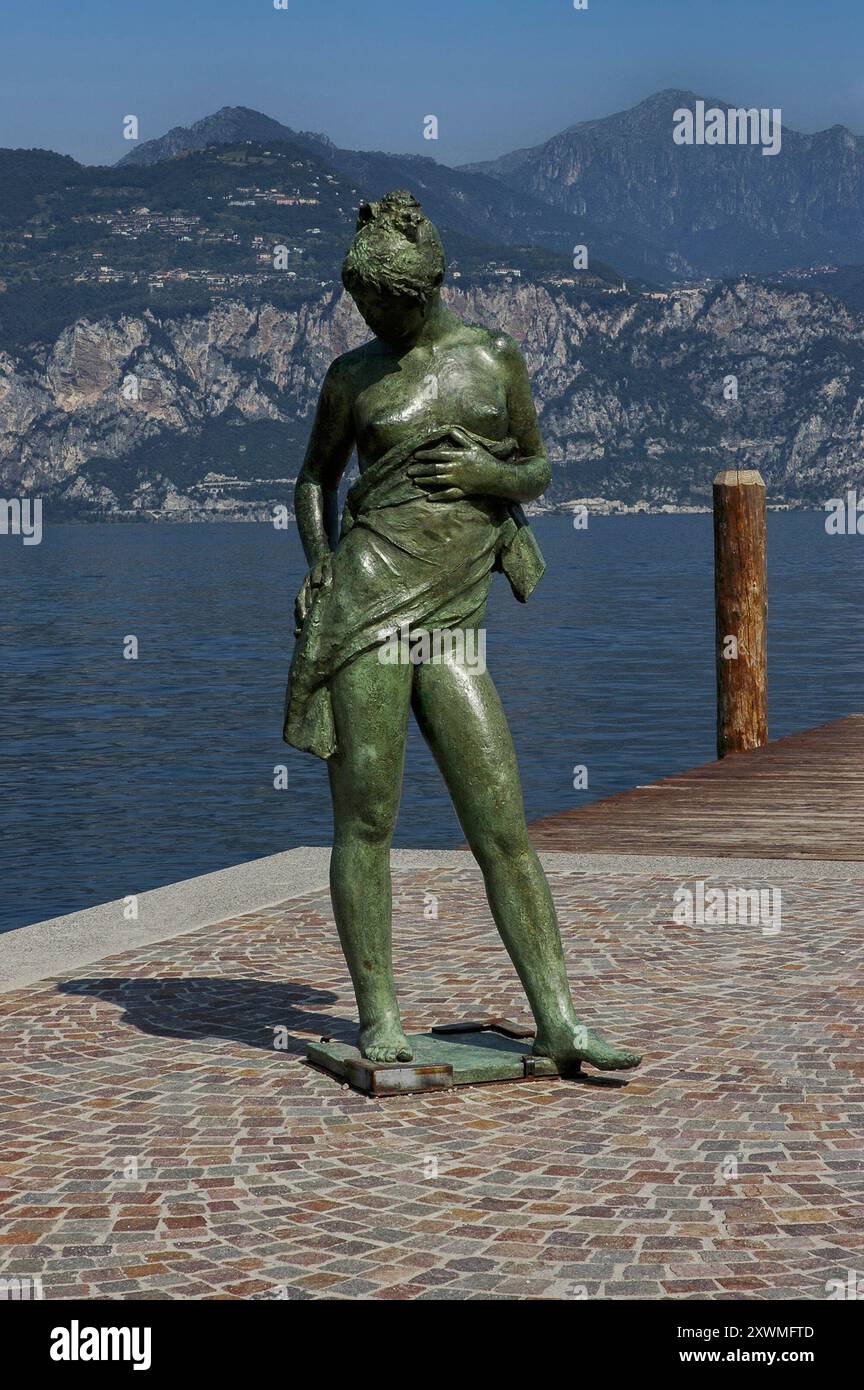 Bagnante statuario si asciuga da sola. Statua in bronzo del 1987 della scultrice spagnola Luisa Granero (1924 - 2012) a Cassone di Malcesine, un villaggio sulla sponda orientale del Lago di Garda, in Veneto. Foto Stock