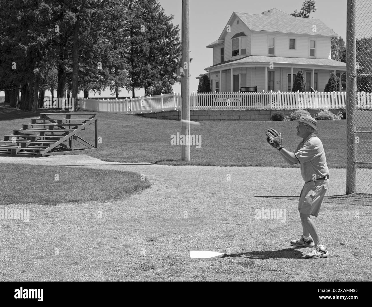 Uomo caucasico, di età compresa tra 50 e 60 anni, che prende una partita di baseball al sito del film Field of Dreams di Dyersville, Iowa, USA. Foto Stock