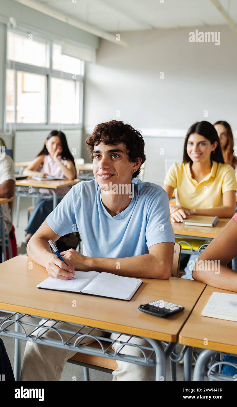 Gruppo giovane di studenti delle scuole superiori che prestano attenzione all'insegnante in classe Foto Stock