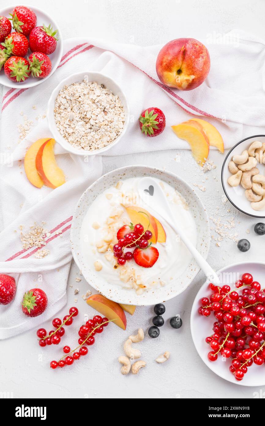 Yogurt greco con frutti di bosco assortiti, noci e fiocchi d'avena Foto Stock