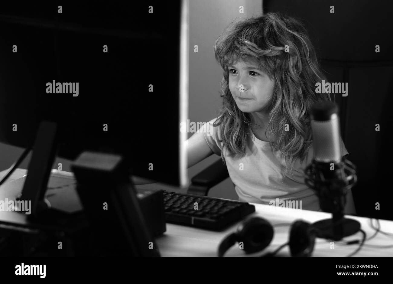 Bambini che giocano a videogame o studiano su pc. Giochi per bambini con illuminazione al neon notturna. Concetto di formazione a distanza. I bambini in linea che lavorano, gioco sopra Foto Stock