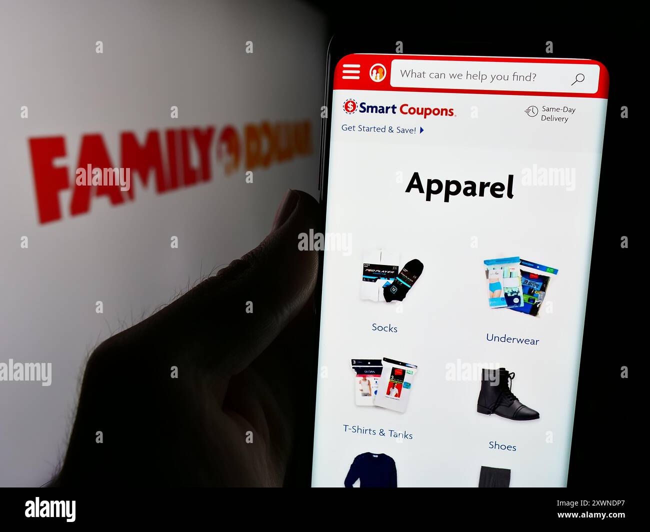 Persona che detiene un cellulare con la pagina Web della società statunitense Family Dollar Stores Inc. Davanti al logo. Messa a fuoco al centro del display del telefono. Foto Stock