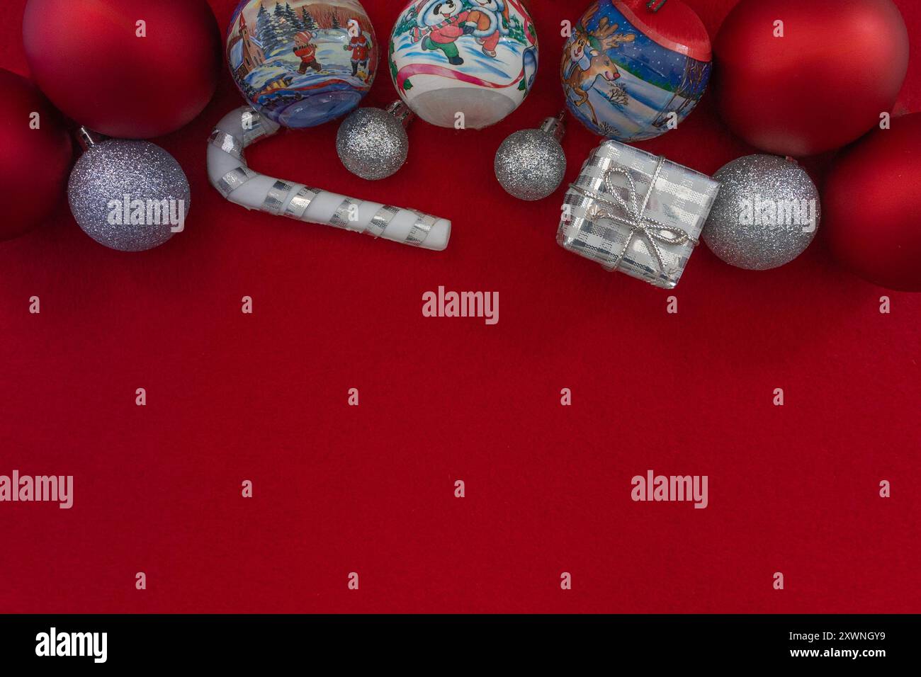 Composizione piatta di ornamenti natalizi su uno sfondo rosso vivace, con ampio spazio per le copie per il testo. Perfetto per design a tema natalizio Foto Stock