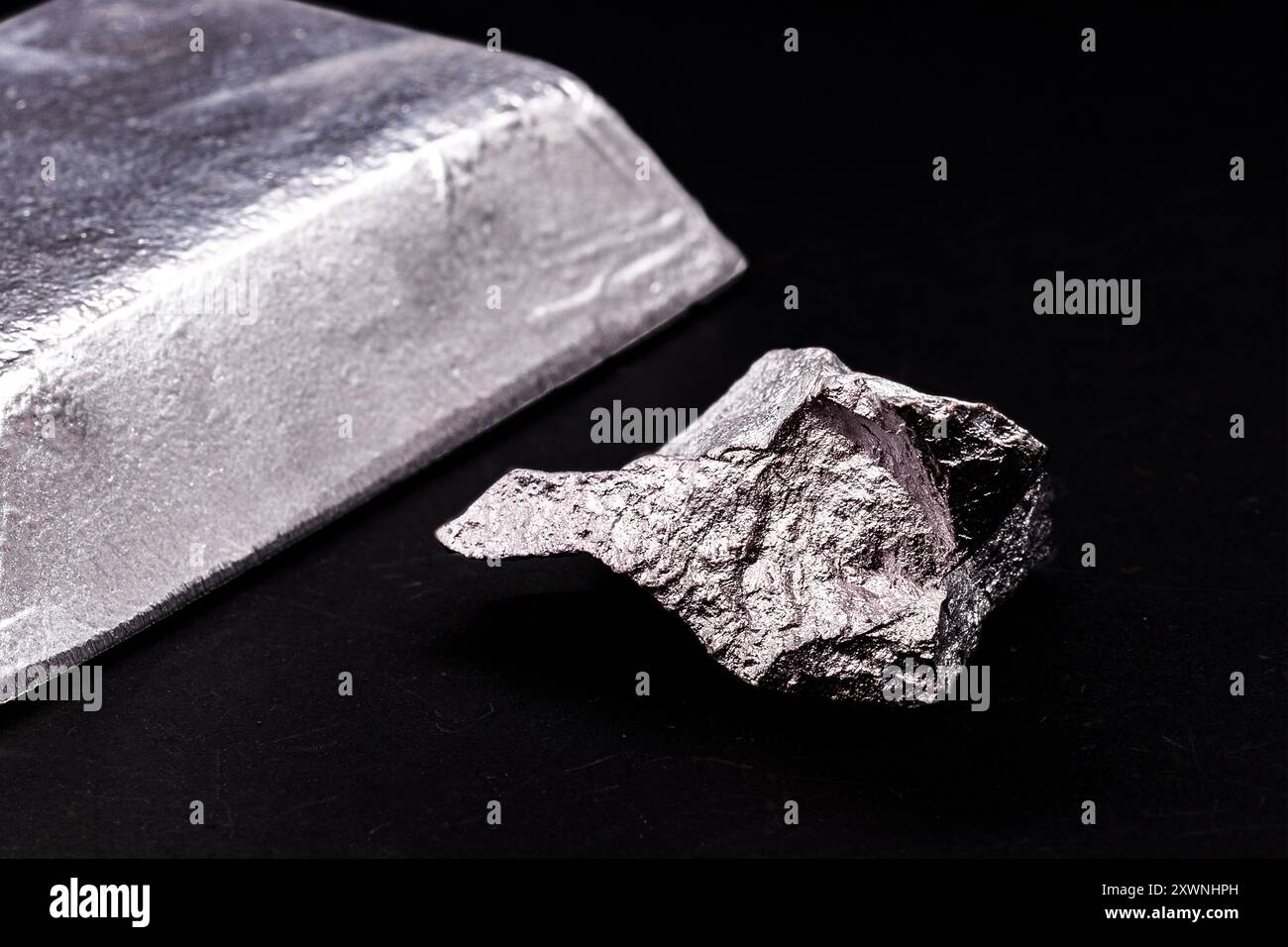 lingotto o barra di alluminio accanto al minerale di alluminio, al riciclaggio o al concetto di industria dei metalli Foto Stock