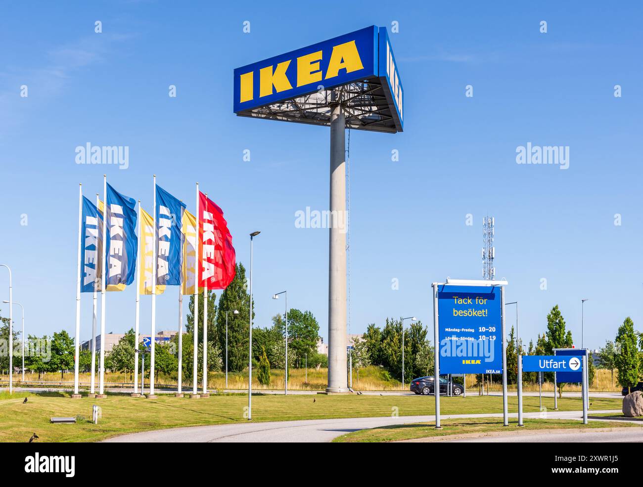 Un alto cartellone su tre lati mostra il cartello IKEA all'ingresso del negozio IKEA di Malmö, Svezia, accanto ai banner IKEA. Foto Stock
