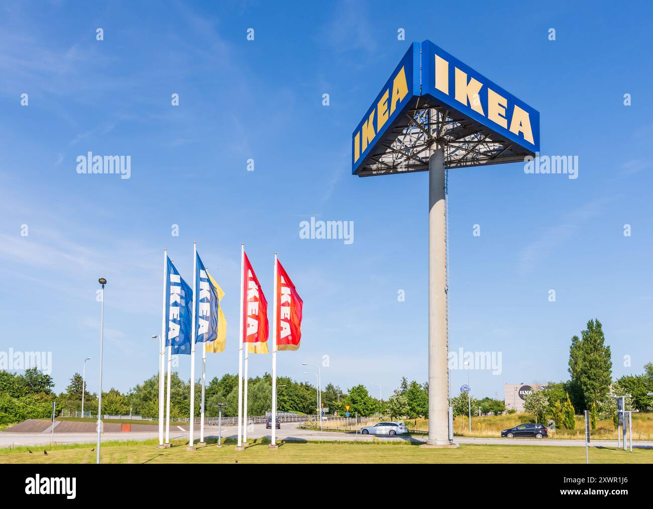 Un alto cartellone su tre lati mostra il cartello IKEA all'ingresso del negozio IKEA di Malmö, Svezia, accanto ai banner IKEA. Foto Stock