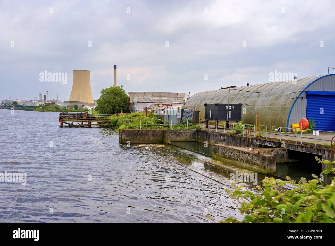 Ellesmere Port Regno Unito 17 agosto 2024. Lungo il fiume industriale Ellesmere Port con centrale elettrica e magazzini sotto un cielo nuvoloso. Foto Stock