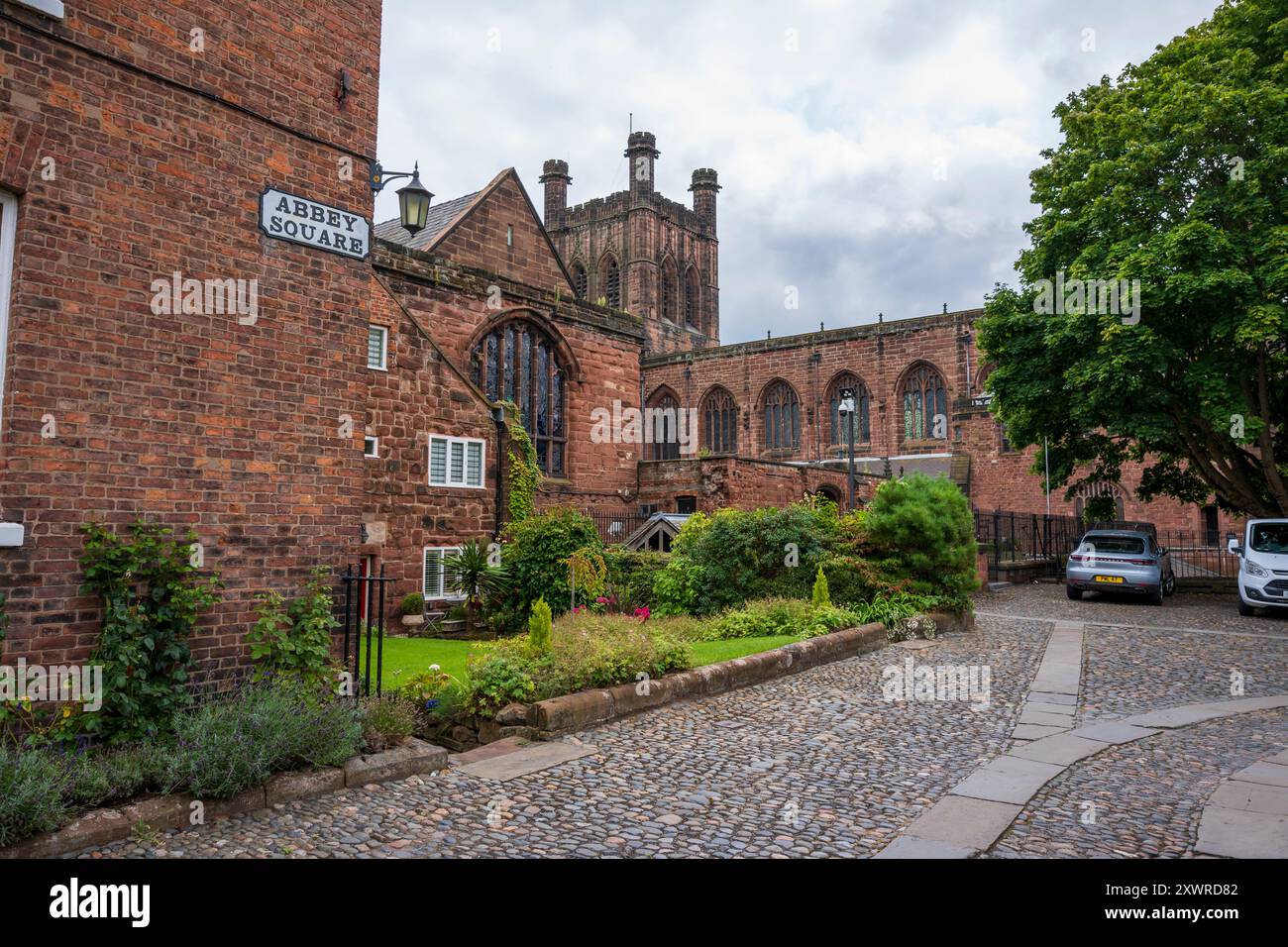 Edifici storici in mattoni e strade acciottolate in Abbey Square, con una cattedrale medievale sullo sfondo. Chester Regno Unito. Foto Stock