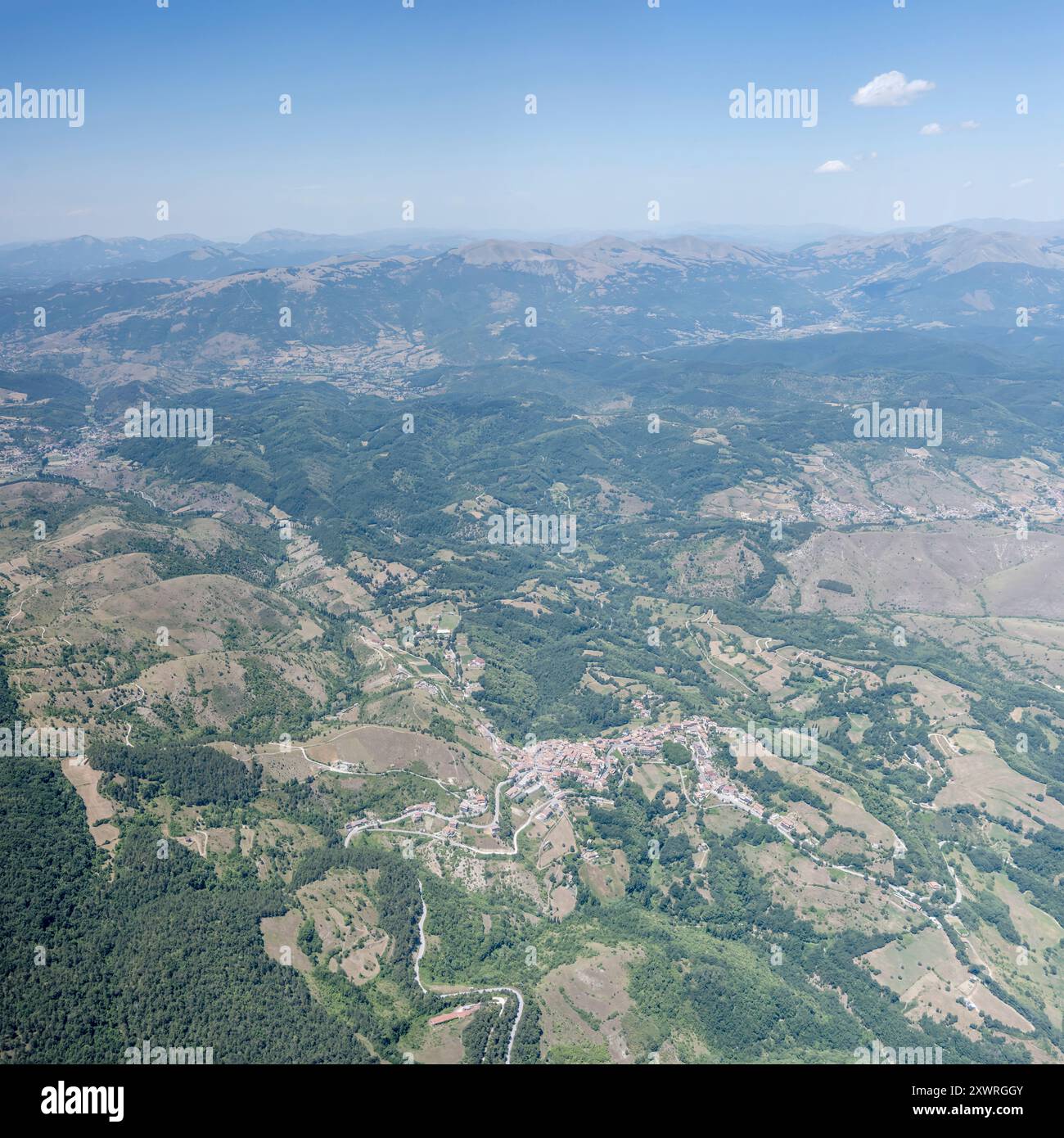 Panorama aereo panoramico della città, da un aereo aliante, con il villaggio di Cesaproba, girato da ovest con la luminosa luce estiva, Appennini, l'Aquila, Abruzzo, Italia Foto Stock