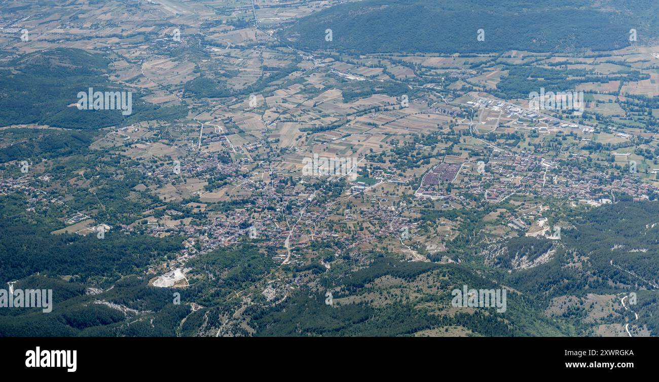 Paesaggio urbano panoramico, da un aereo aliante, con il villaggio di Pizzoli, girato da nord con la luce estiva, Appennini, l'Aquila, Abruzzo, Italia Foto Stock