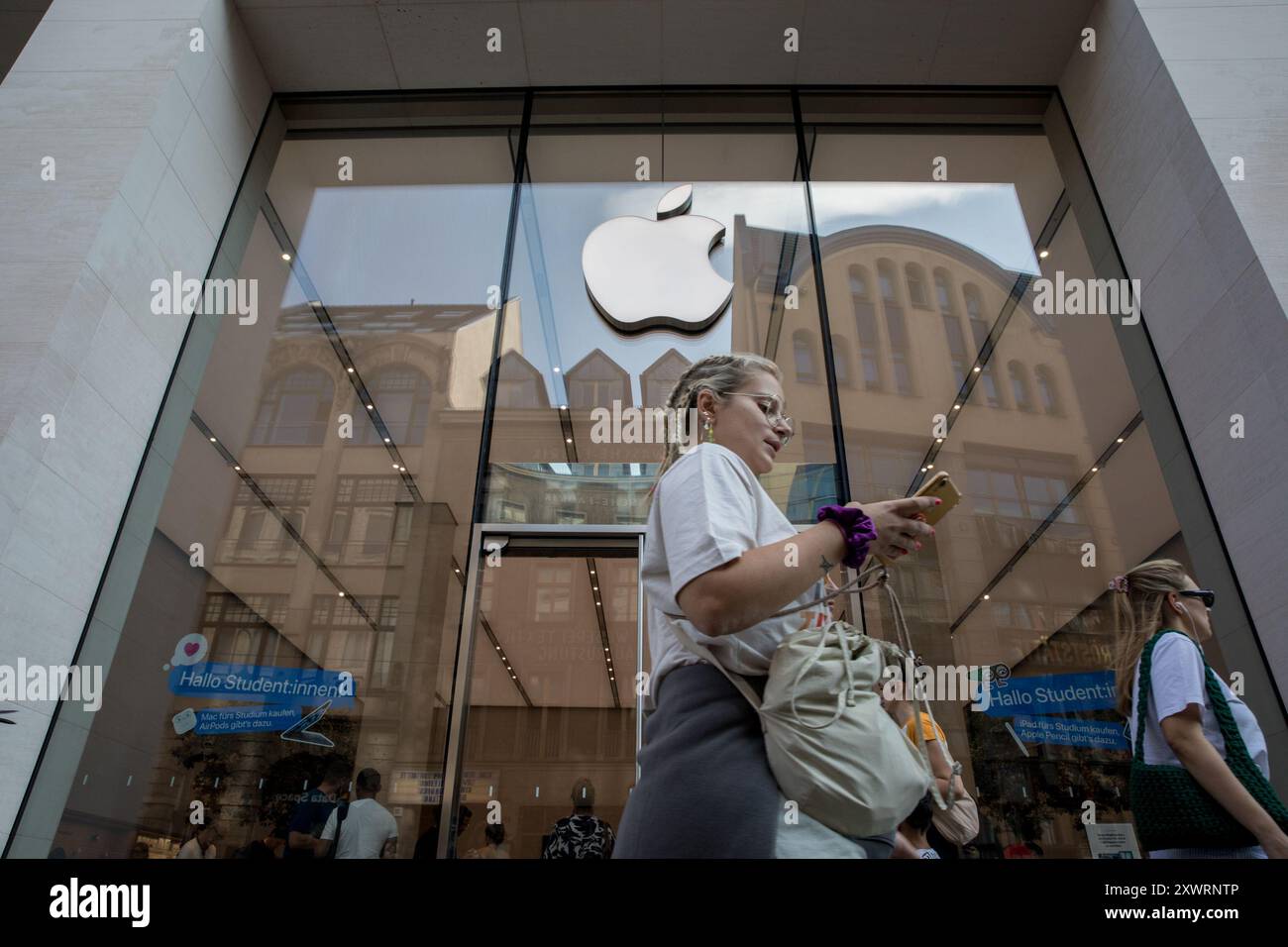 Berlino, Germania. 20 agosto 2024. L'iconico logo Apple si trova in primo piano sopra l'ingresso dell'Apple Store sulla Rosenthaler Strasse a Berlino il 20 agosto 2024. Il negozio, noto per il suo design elegante e i prodotti innovativi, attira un flusso costante di clienti desiderosi di esplorare le ultime novità della tecnologia Apple. (Foto di Michael Kuenne/PRESSCOV/Sipa USA) credito: SIPA USA/Alamy Live News Foto Stock