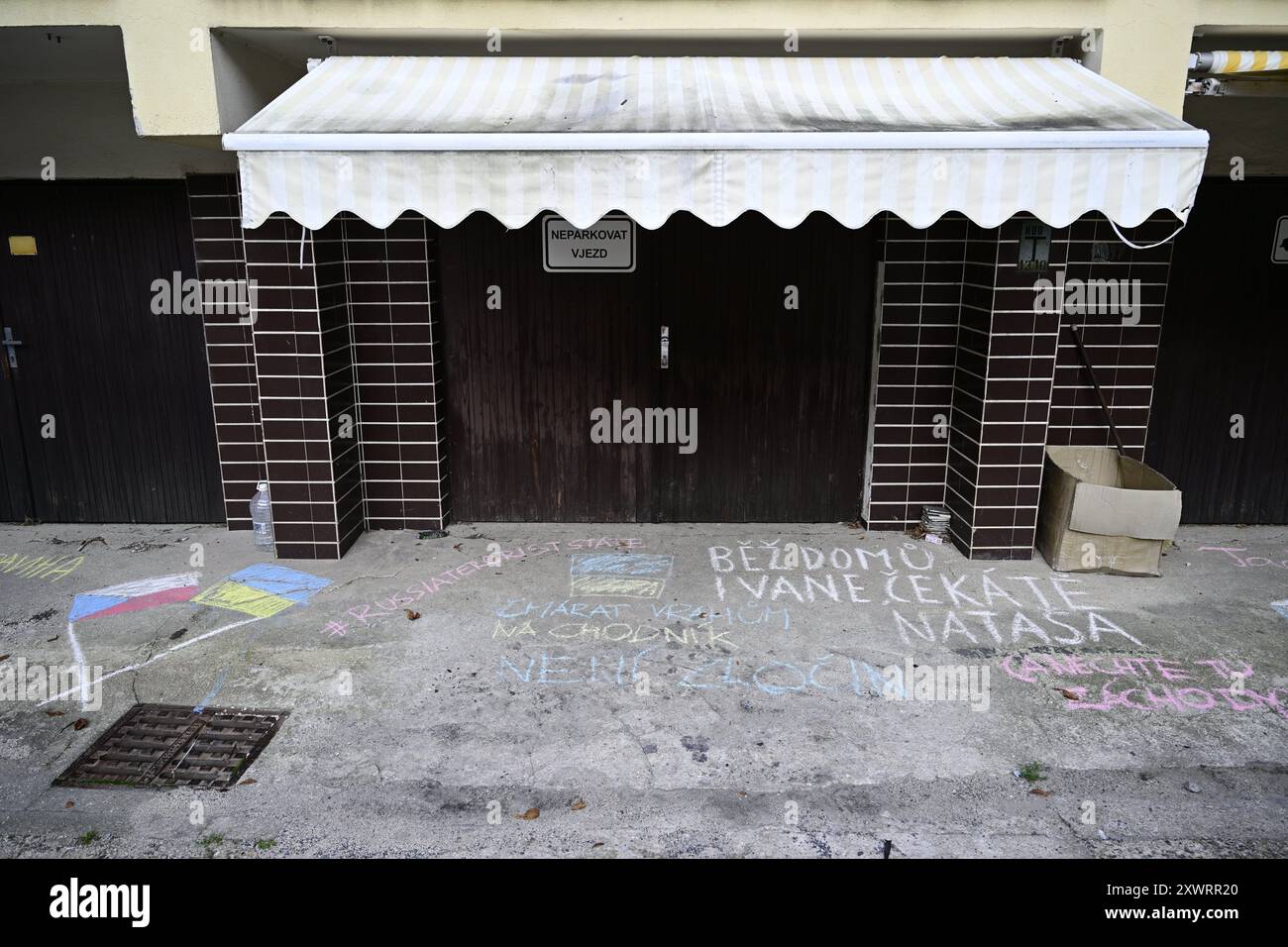 Praga, Repubblica Ceca. 20 agosto 2024. L'evento intitolato "We Say: This is not Russia”, che sostiene gli attivisti che sono perseguiti per aver disegnato la bandiera Ucraina sul marciapiede di fronte agli immobili russi, indicando la minaccia alla sicurezza che la Russia pone attraverso le sue proprietà, si è tenuto in occasione dell'anniversario dell'occupazione sovietica della Cecoslovacchia nel 1968, in via Schwaiger a Praga, Repubblica Ceca, il 20 agosto 2024. Sulla foto sono visibili dei cartelli sul marciapiede di fronte alle case russe, che sono stati dipinti dai partecipanti all'evento. Crediti: Roman Vondrous/CTK Photo/Alamy Live News Foto Stock