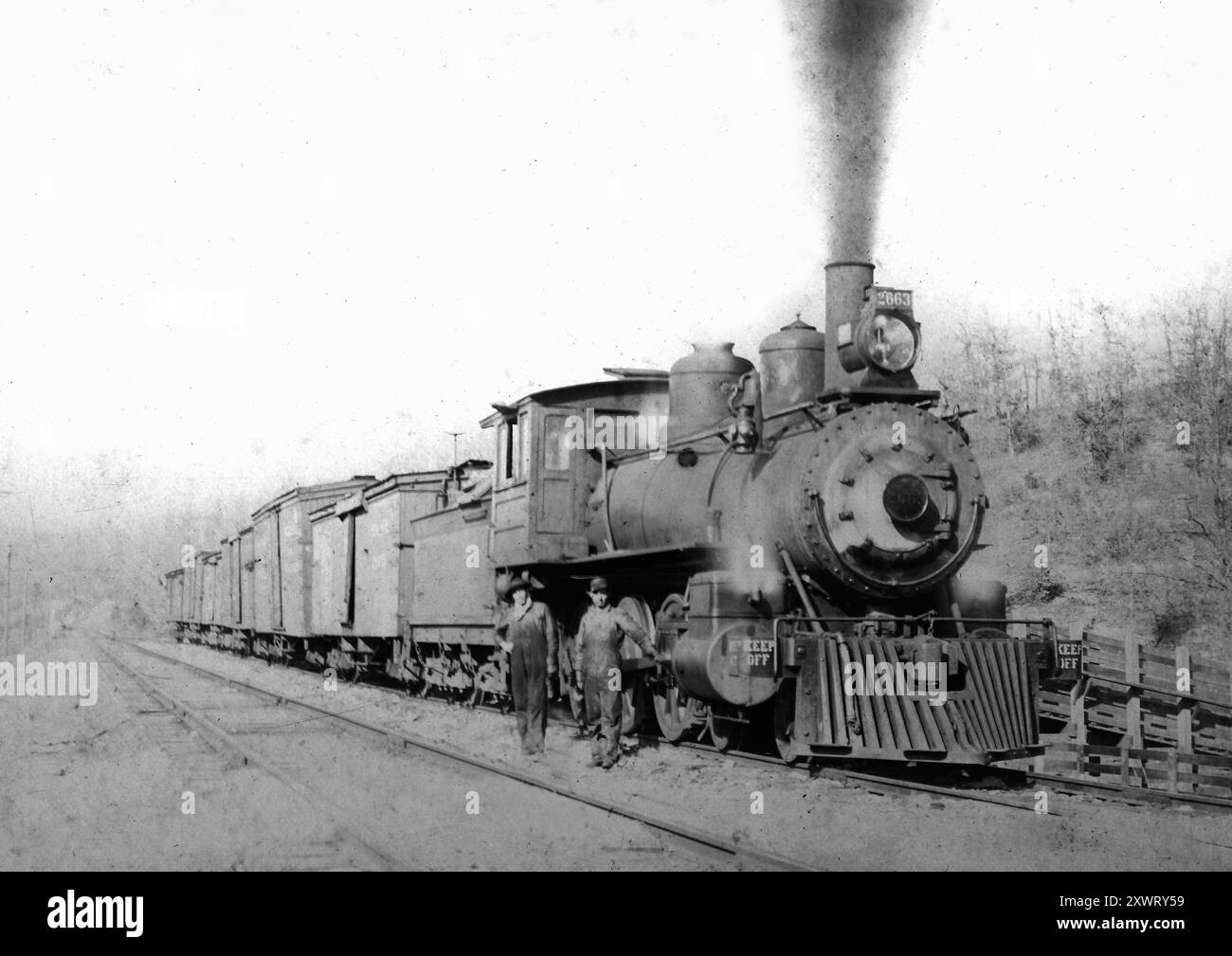 Un ingegnere ferroviario e un vigile del fuoco stanno accanto alla loro locomotiva, ca. 1900 Foto Stock