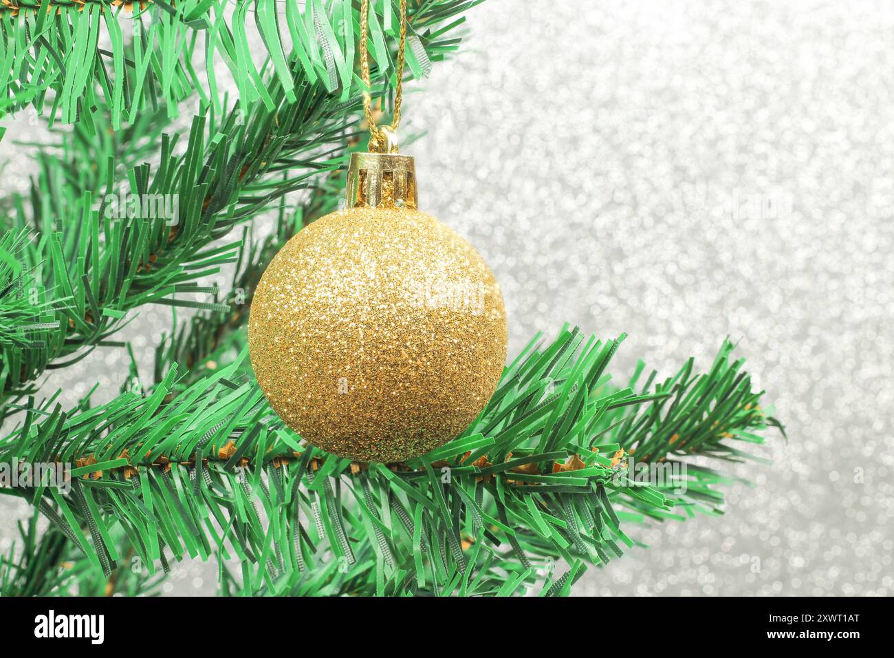 Idea del nuovo anno. Palle d'oro sull'albero di Natale isolate su sfondo grigio. Preparazione per la celebrazione del nuovo anno. Foto Stock