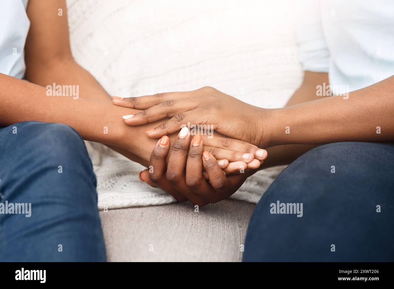 Famiglia afroamericana che tiene le mani sul divano Foto Stock