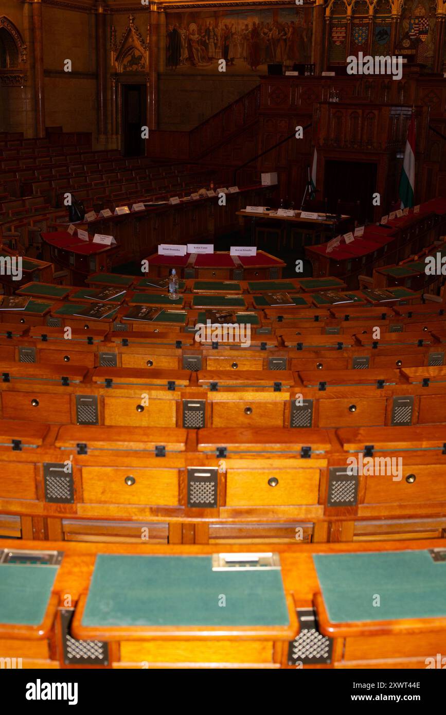 All'interno dell'edificio del Parlamento ungherese a Budapest, raffigurante il design ornato e i posti legislativi vuoti. L'immagine rappresenta la governance, il patrimonio e l'identità nazionale. Adatto a temi di politica, storia e architettura. Foto Stock