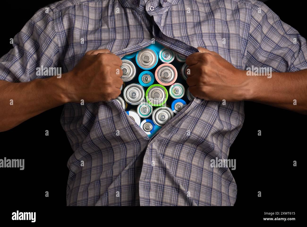 L'uomo lacera la camicia aperta, rivelandosi all'interno pieno di batterie, simboleggiando energia e potenza Foto Stock