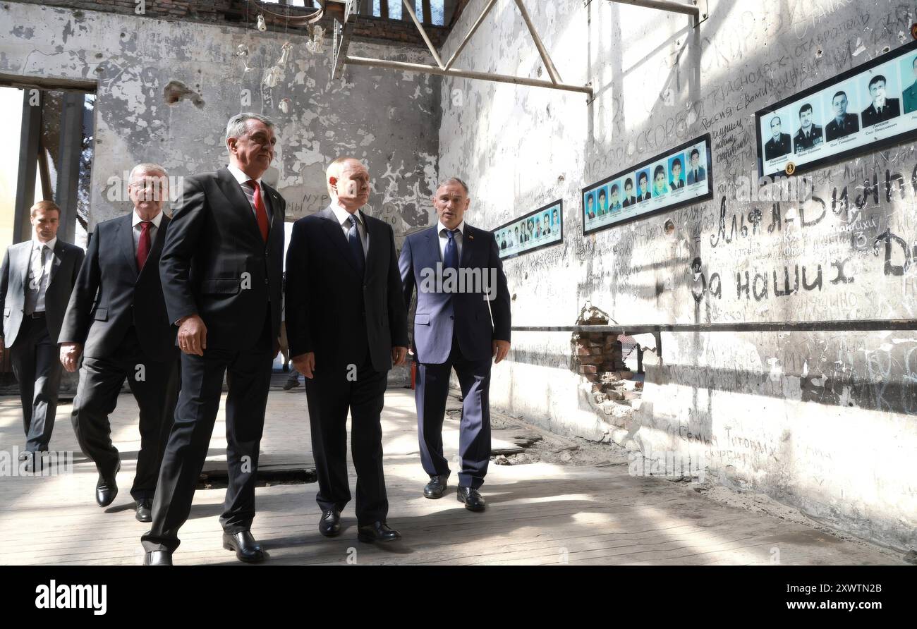 Beslan, Russia. 20 agosto 2024. Il presidente russo Vladimir Putin, al centro, accompagnato dal capo Ossezia settentrionale-Alania Sergei Menyailo, seconda a sinistra, e dall'inviato del distretto federale del Caucaso settentrionale Yury Chaika, a sinistra, visita l'ex scuola Beslan n. 1, 20 agosto 2024 a Beslan, Repubblica dell'Ossezia settentrionale-Alania, Russia. La scuola è il luogo del più letale sparatoria scolastica della storia che si conclude con la morte di 334 persone. Crediti: Vyacheslav Prokofyev/piscina del Cremlino/Alamy Live News Foto Stock