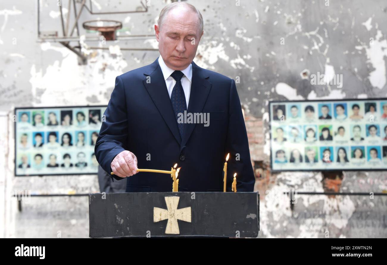 Beslan, Russia. 20 agosto 2024. Il presidente russo Vladimir Putin, accende una candela in un memoriale all'interno dell'ex scuola Beslan n. 1, 20 agosto 2024 a Beslan, Repubblica dell'Ossezia del Nord-Alania, Russia. La scuola è il luogo del più letale sparatoria scolastica della storia che si conclude con la morte di 334 persone. Crediti: Vyacheslav Prokofyev/piscina del Cremlino/Alamy Live News Foto Stock