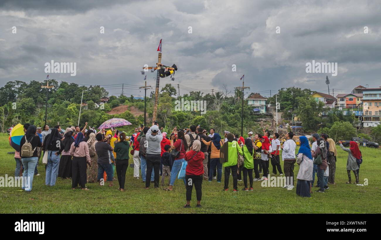 Balikpapan, Indonesia - 18 agosto 2024. L'arrampicata femminile viene rallegrata dalla folla durante l'arrampicata sulle palme o la gara di pinang del panjat. Foto Stock