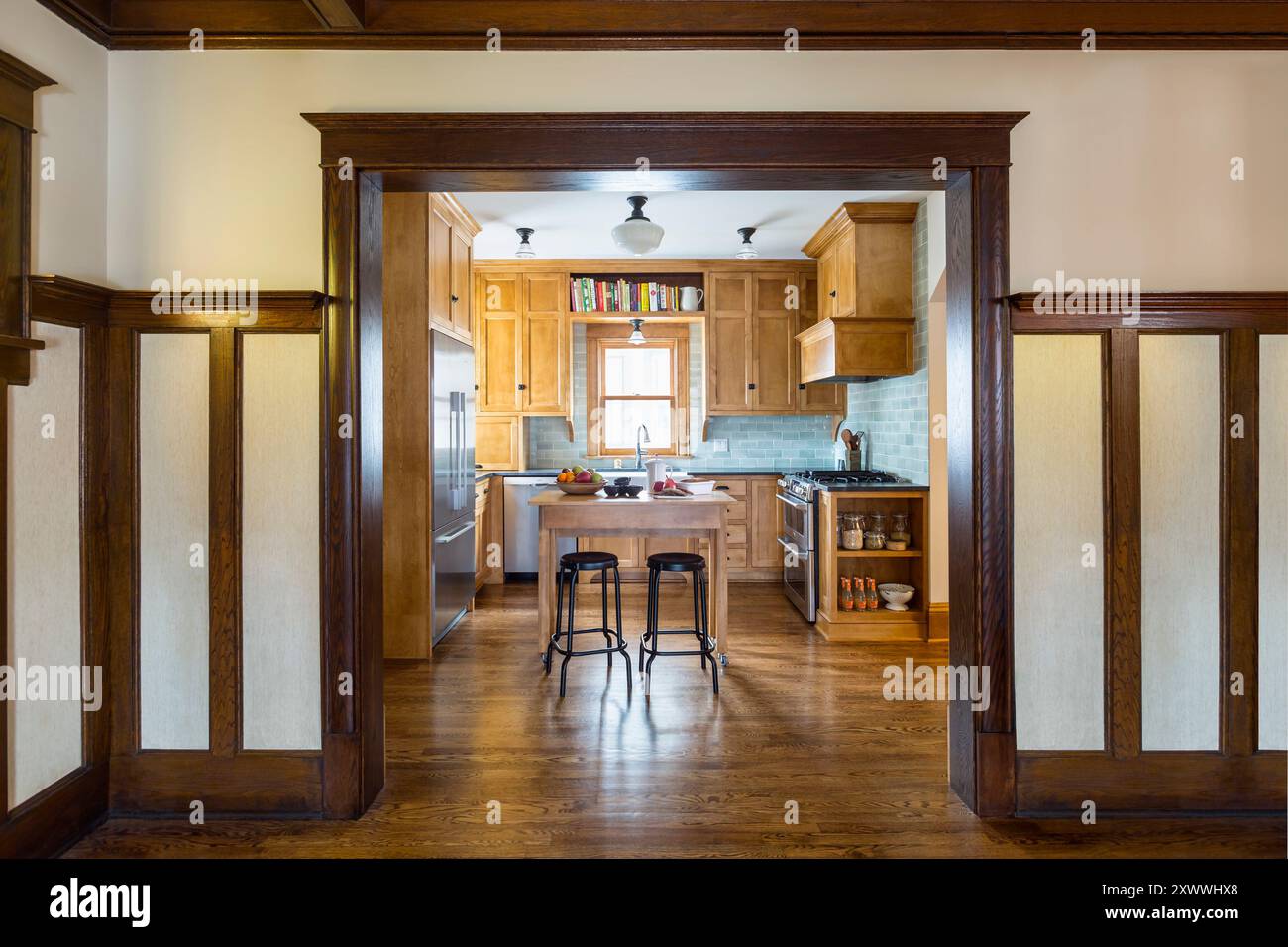 Cucina ristrutturata che si adatta bene alla casa originale, vista dall'ingresso con splendide opere in legno Foto Stock