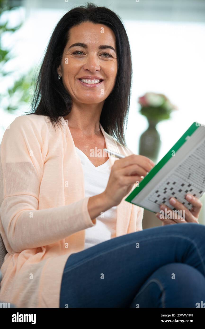 premuroso attraente donna che risponde cruciverba puzzle Foto Stock