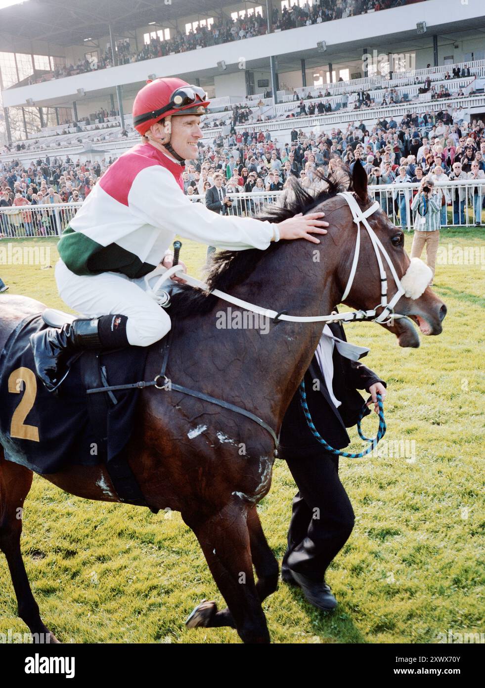 Il cavallo da corsa e fantino Andreas Suborics celebrano la vittoria nella prima gara della stagione 2011 a Hoppegarten, Berlino. Un momento emozionante che cattura l'emozione delle corse di cavalli e il successo trionfale tra una folla entusiasta. Foto Stock