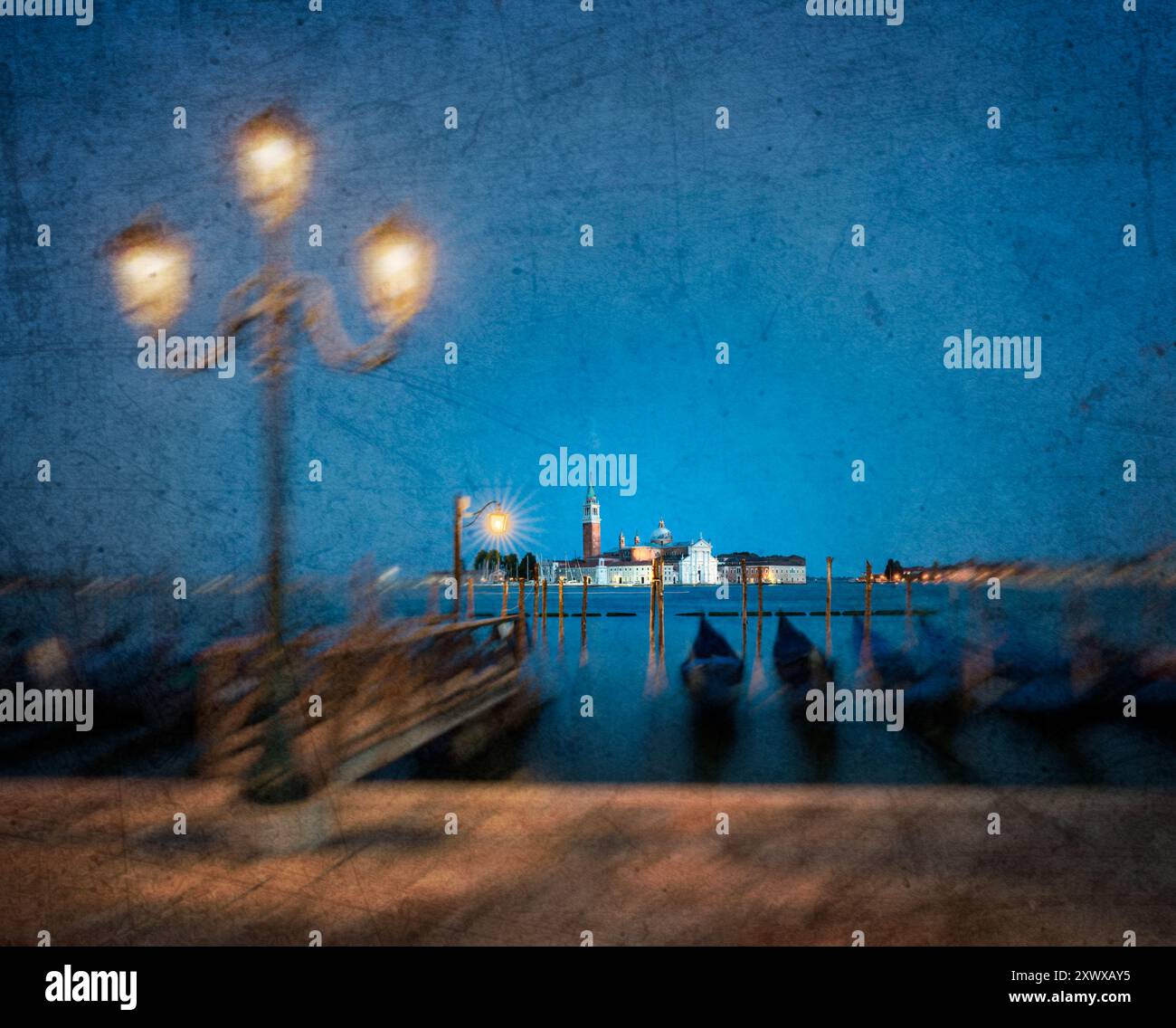 Un'immagine classica di Venezia ma con un effetto angosciato che enfatizza l'intenso blu del cielo con la tradizionale illuminazione stradale Foto Stock