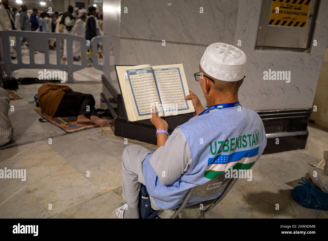 Mecca, Arabia Saudita - 6 giugno 2024: Un vecchio pellegrino, Hajj e Umrah dall'Uzbekistan seduto e leggendo il Corano a Masjidil Haram, grande Moschea di ma Foto Stock