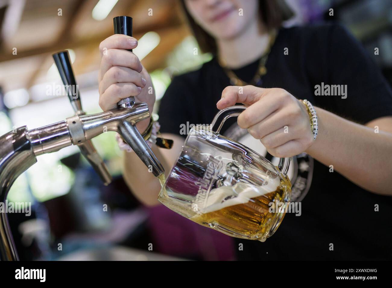 Symbolfoto zum Thema Ausschank von Bier. Eine Frau zapft ein Fassbier in einem Cafe a Berlino, 14.08.2024. Berlin Deutschland *** foto simbolica su Th Foto Stock