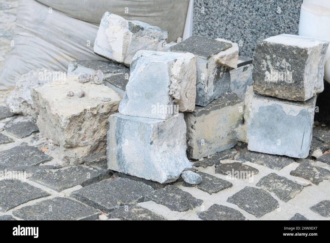 Mattoni grigi per la riparazione. I marciapiedi sono disposti su strada. Riparazione stradale in città. Nuovo marciapiede. Foto Stock