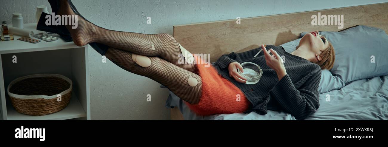 Una donna con un elegante abbigliamento grungy si rilassa su un letto, in un ambiente confortevole e informale. Foto Stock