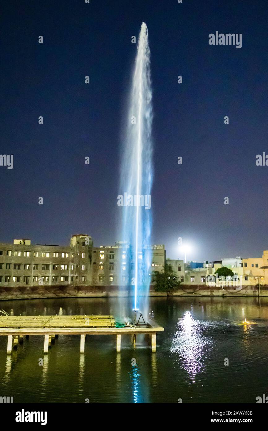 fontana con un lungo getto d'acqua di notte Foto Stock