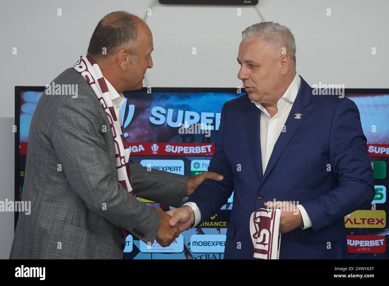 Bucarest, Romania. 21 agosto 2024: Dan Sucu (L), finanziatore del Rapid FC, saluta Marius Sumudica (R), il nuovo allenatore del Fotbal Club Rapid Bucarest, durante una conferenza stampa, alla Superbet Arena-giulesti di Bucarest. Crediti: Lucian Alecu/Alamy Live News Foto Stock