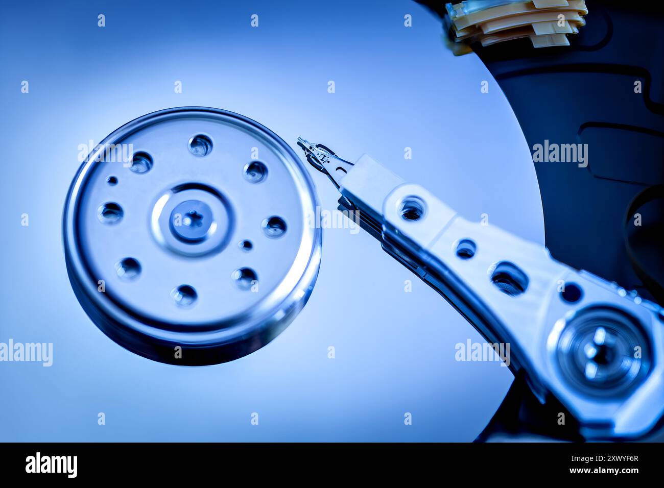 Primo piano del braccio di lettura/scrittura e del piatto di un disco rigido portatile, che mostrano meccanica interna, tecnologia di archiviazione dei dati e precisione digitale. Foto Stock