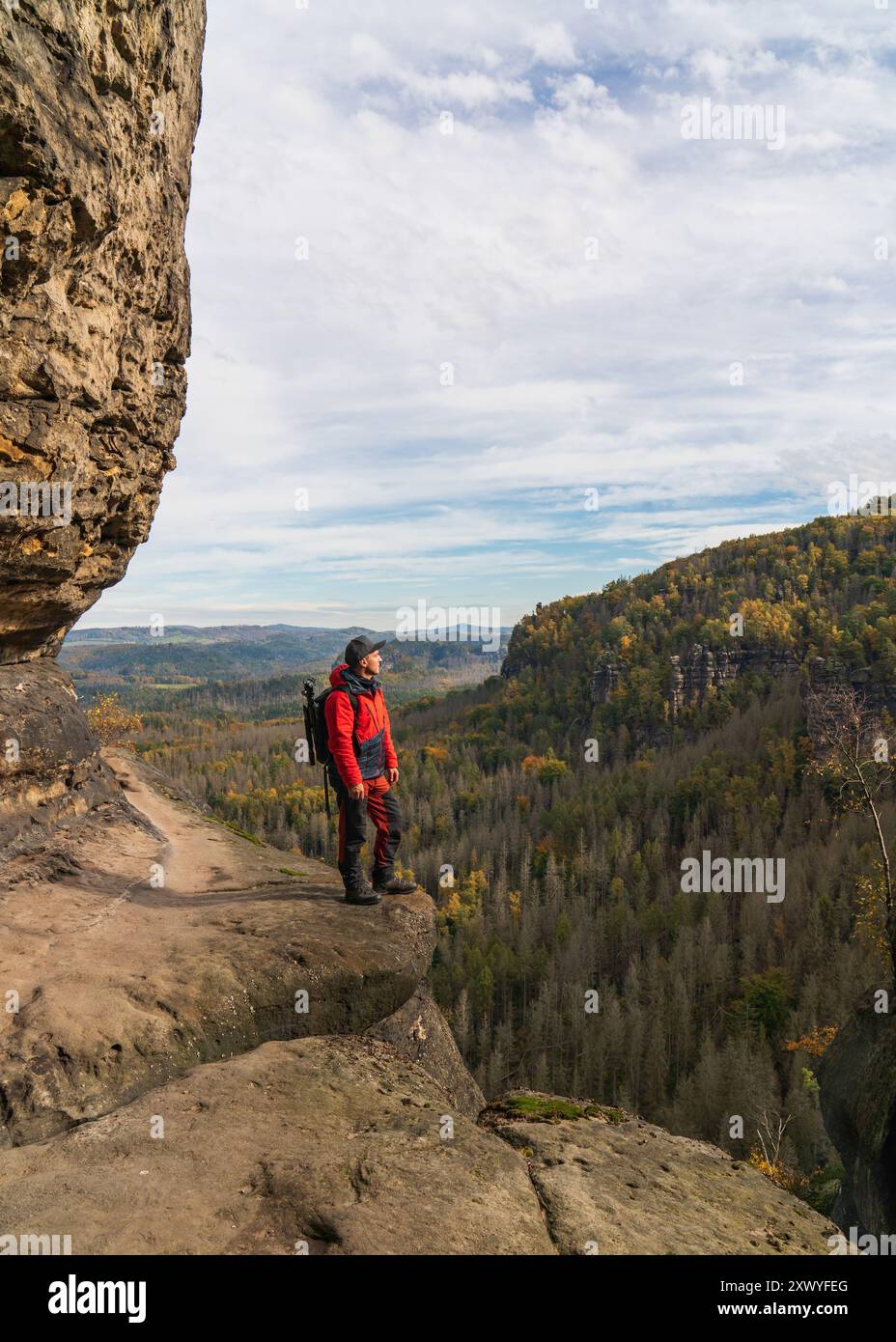 Fotografo viaggiatore con zaino fotografico e cavalletto su una roccia. Parco nazionale della Svizzera sassone. Germania Foto Stock