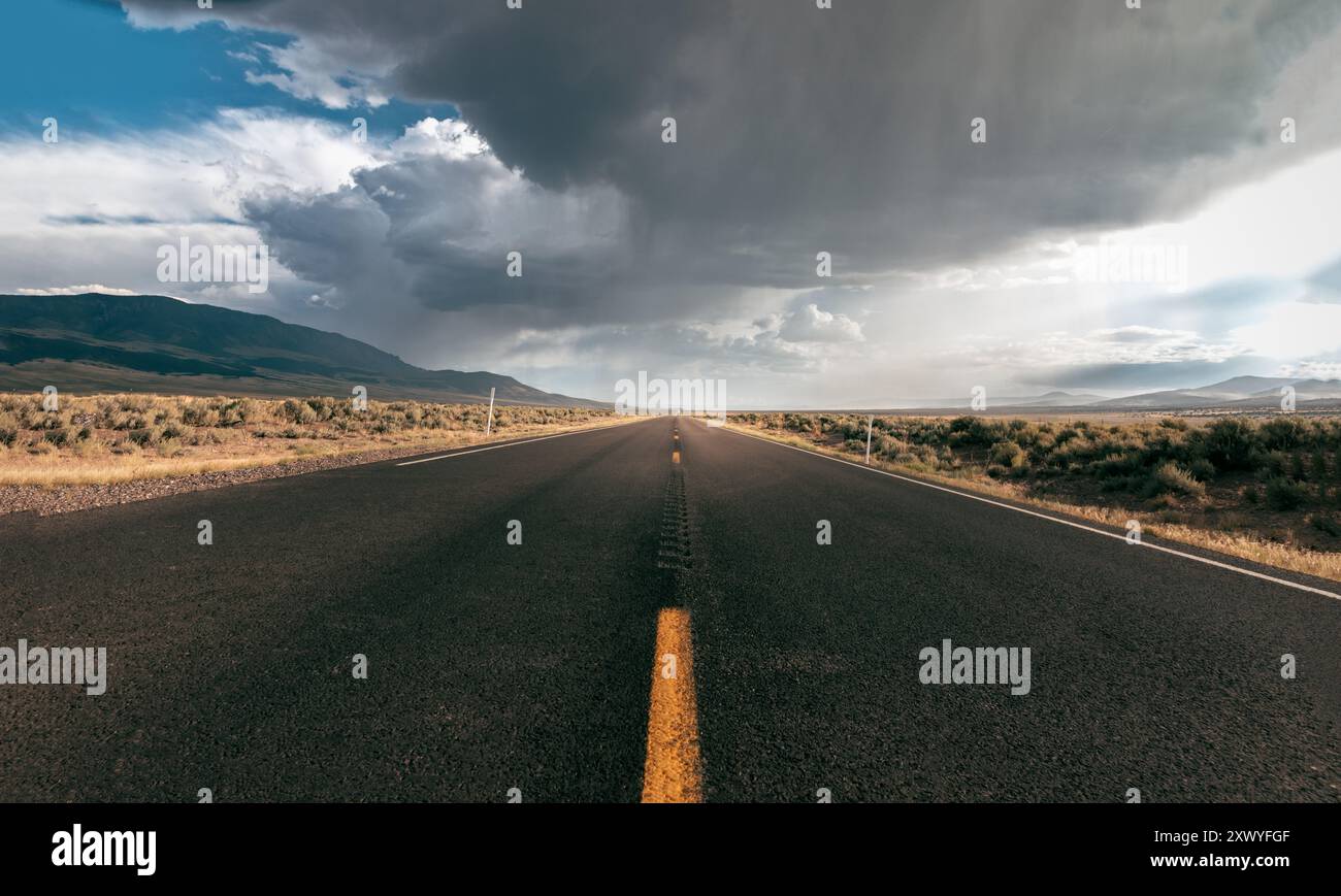 Strada infinita nel Midwest degli Stati Uniti sotto un cielo buio e drammatico Foto Stock