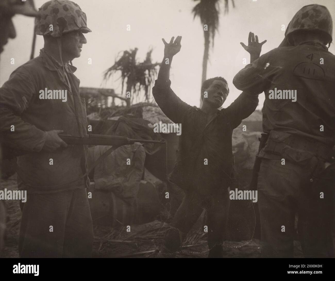 La seconda guerra mondiale teneva le mani in alto, il soldato giapponese dice ai suoi marinai che c'è un altro dentro che ha paura di arrendersi. 1943-1945 Foto Stock