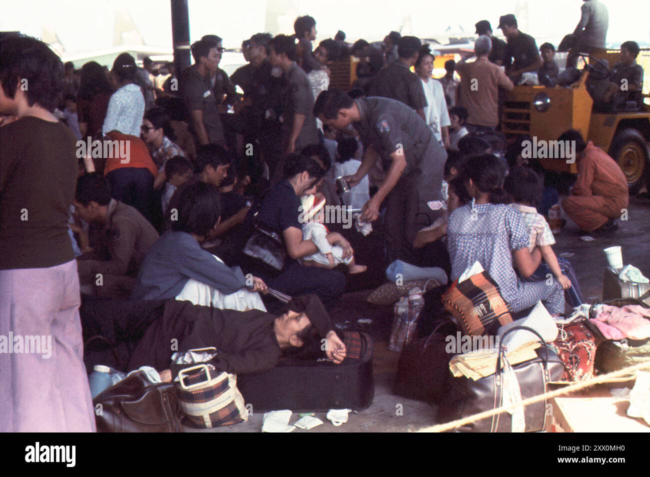 L'evacuazione aerea dei vietnamiti colpiti dall'assedio da Saigon agli Stati Uniti fu condotta dopo l'operazione Babylift. Militanti vietnamiti e civili attendono il loro viaggio C-141 durante lo scalo. Utapo RTNAF, Tailandia. 29 aprile 1975 Foto Stock