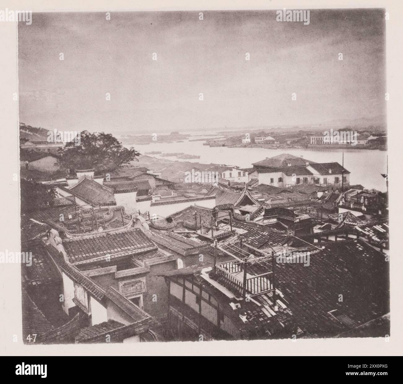 Foto d'epoca di parte dell'insediamento straniero, Foochow (Fuzhou). Illustrazioni di Qing Cina, 1875 Fuzhou è la capitale e una delle città più grandi della provincia del Fujian, in Cina. Questa foto è stata scattata dall'estremità superiore dell'insediamento straniero, guardando attraverso l'ampia superficie del min. Questa immagine è preziosa, in quanto mostra il piano di una casa cinese, generale tra le classi medio-basse. L'ingresso della strada è purtroppo nascosto da un muro che taglia l'angolo sinistro del primo piano della foto. La parete esterna in mattoni dell'abitazione è sollevata all'altezza del tetto e include Foto Stock