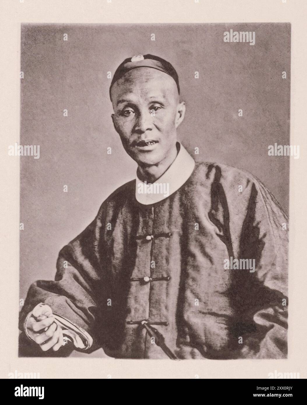 Foto d'epoca del gentiluomo cantonese. Illustrazioni di Qing China, 1875 ... l'uomo rappresentato dal ritratto davanti a noi è colui che, fin dai primi anni di vita, si dedicò assiduamente allo studio della letteratura e che, avendo ottenuto una o due lauree agli esami civili del governo, mostrò una conoscenza competente dei classici, delle leggi, e la storia della Cina, ha fatto iscrivere il suo nome come membro non iscritto del servizio civile cinese. Nel corso del tempo divenne un funzionario salariato, e un mandarino di sesta grado. Quando è vestito in costume ufficiale, il suo rango è indicato dallo stilo Foto Stock