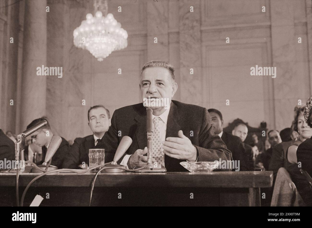 Foto d'epoca del mafioso Joseph 'Joe Cago' Valachi della famiglia criminale genovese, che testimonia della criminalità organizzata e della mafia in un'audizione della sottocommissione permanente sulle indagini della commissione del Senato per la sicurezza interna e gli affari governativi (comitato McClellan), come man indica la mappa delle organizzazioni mafiose. USA, 1 ottobre 1963 di W.K. Leffler Foto Stock