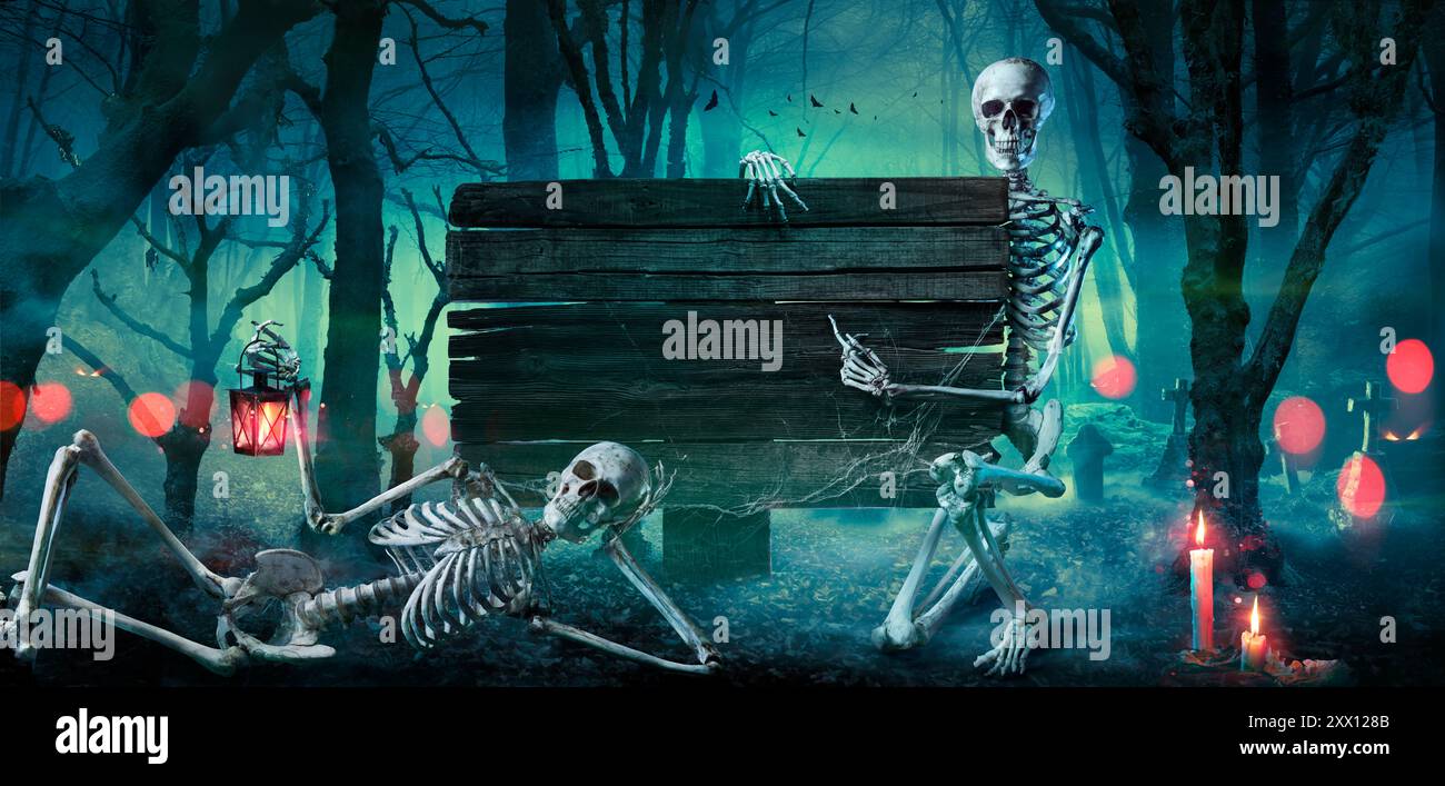 Halloween Card - Foresta con cartello in legno - Cimitero di notte con scheletri Foto Stock