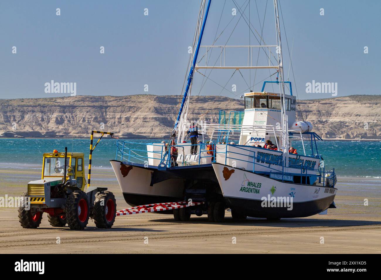 Una barca commerciale per l'avvistamento delle balene viene lanciata sulla spiaggia con la bassa marea a Puerto Pyramides, Golfo Nuevo, Argentina, Sud America Foto Stock