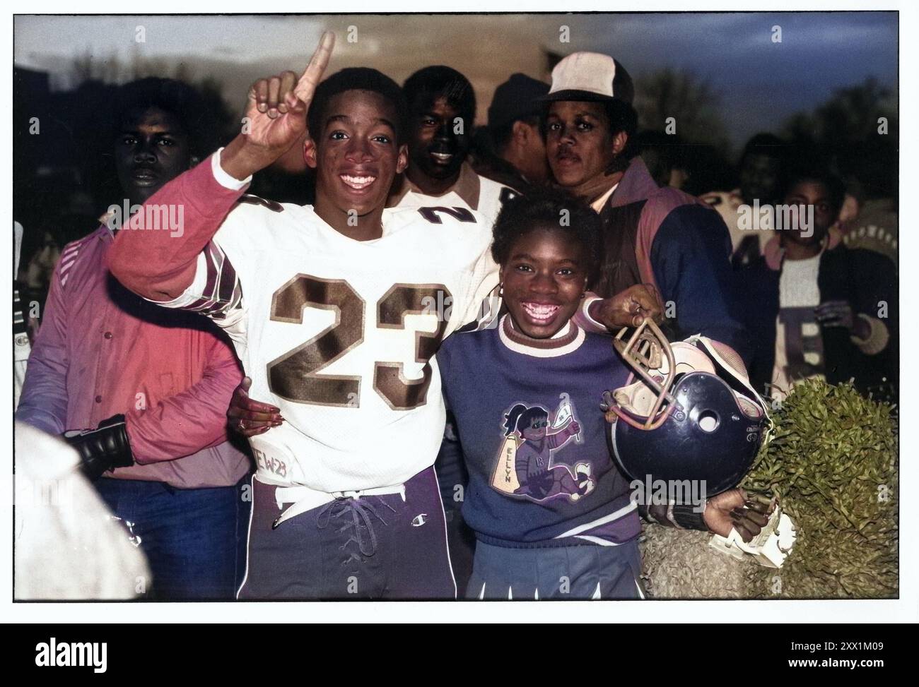 Dopo aver vinto la partita, un giocatore di football della Bayside High School ha posato per una foto con la sua fidanzata cheerleader. A Brooklyn, New York nel 1983. Questa foto è stata originariamente realizzata in bianco e nero e convertita in colore su Photoshop Foto Stock