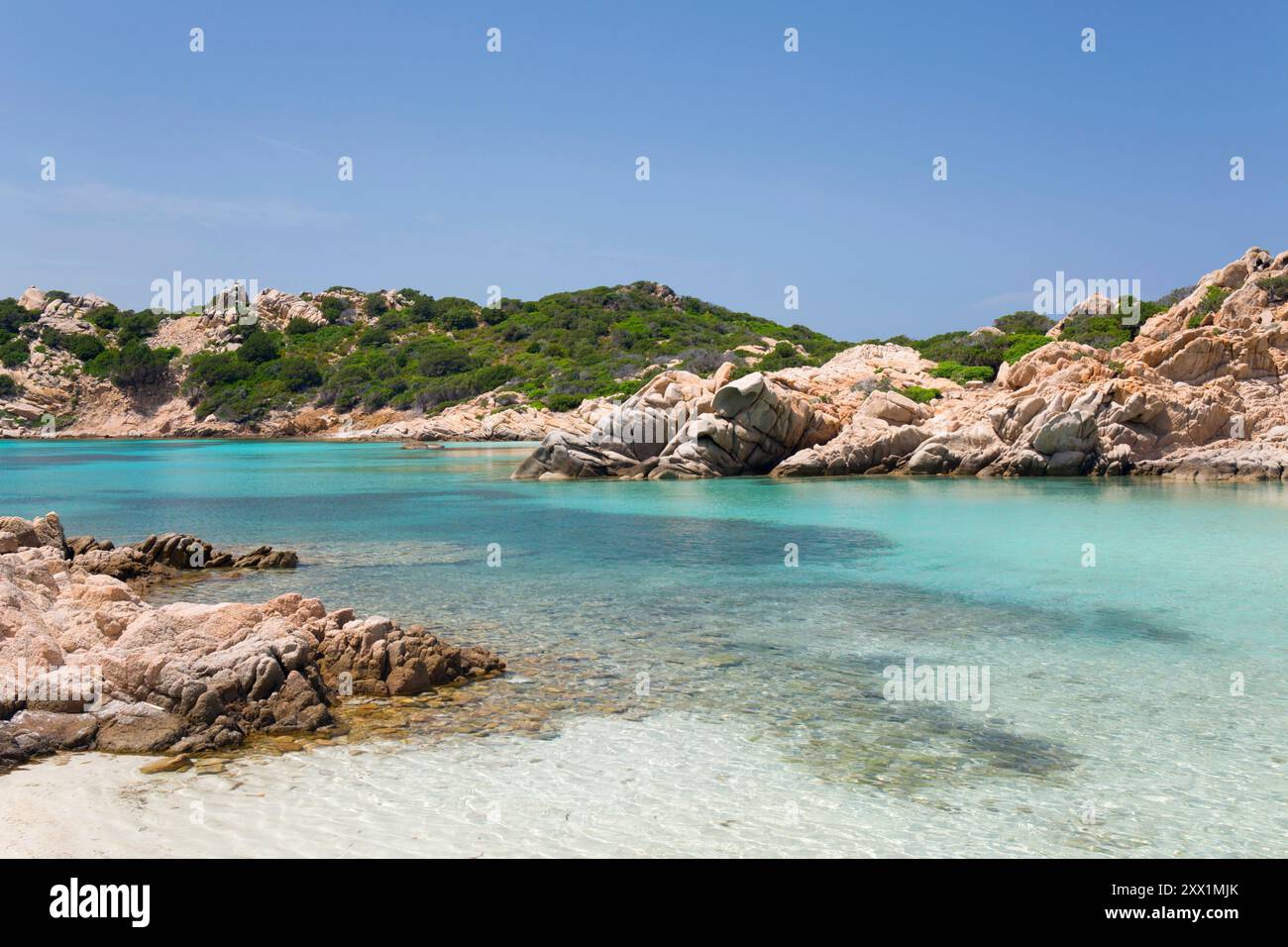 Vista dalla costa attraverso le calme acque turchesi di Cala Napoletana, l'isola di Caprera, il Parco Nazionale dell'Arcipelago la Maddalena, Sassari, Sardegna Foto Stock